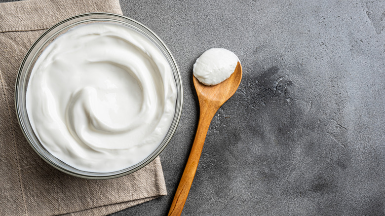 Plain yogurt with wooden spoon