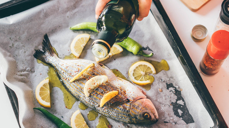 fish being marinated on tray with lemons