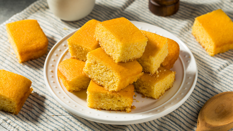 Homemade squares of cornbread on a plate.