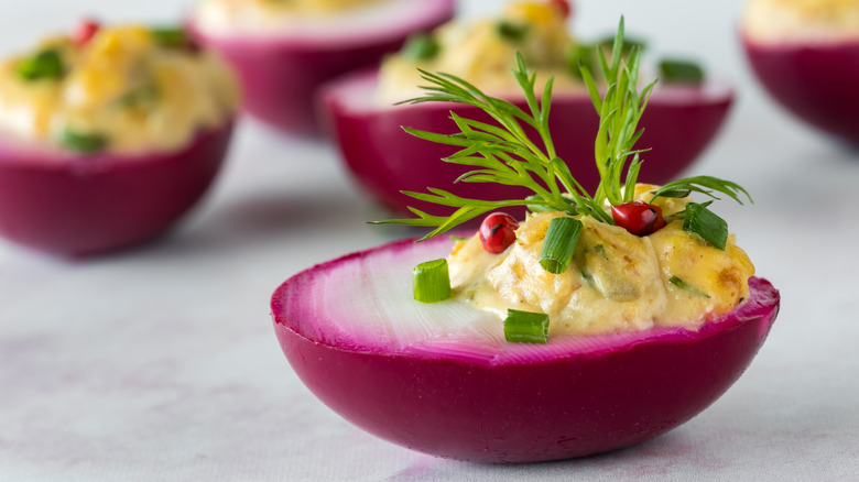 purple deviled egg with fresh herbs
