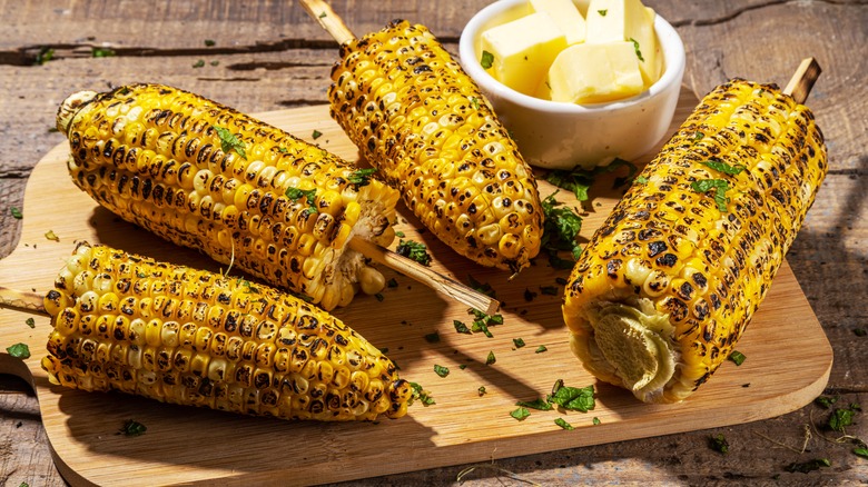 Grilled corn on a cutting board with butter