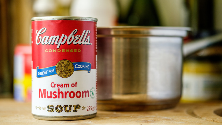 Canned cream of mushroom soup next to a pot