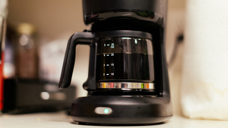 A coffee maker with freshly brewed coffee in its pot