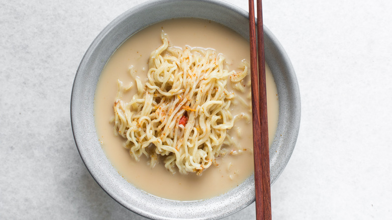 creamy noodles in a bowl with chopsticks on the side