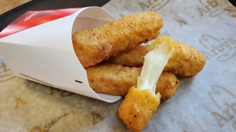 A four-piece order of Arby's mozzarella sticks inside a branded container