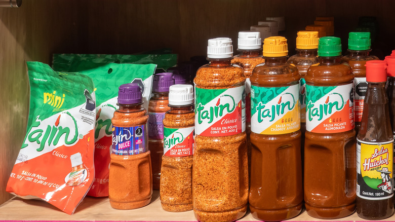 Tajin and hot sauces on grocery store shelves.
