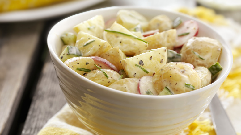 white bowl with potato salad and herbs