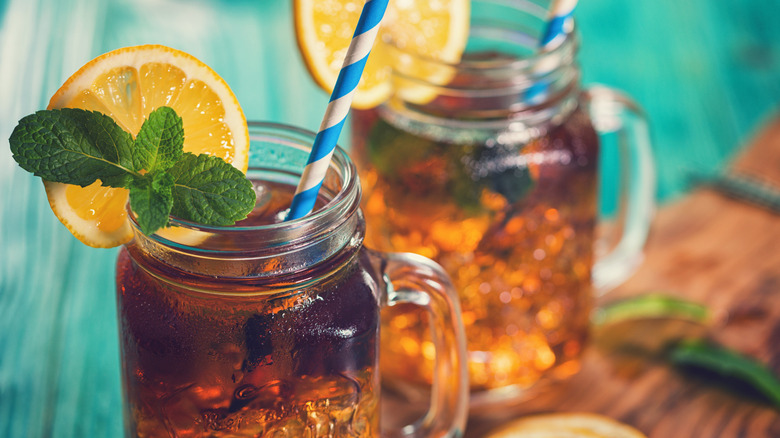 A glass of sweet tea over ice, garnished with mint and a lemon wheel.
