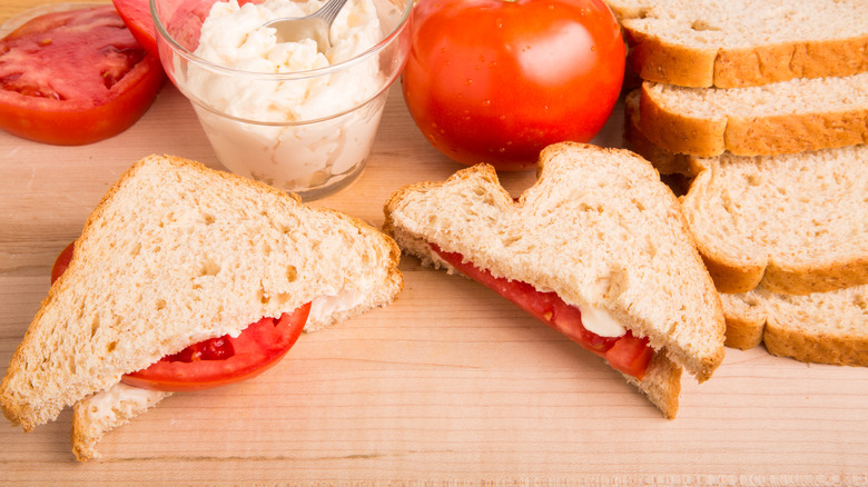 A classic tomato sandwich on a cutting board.