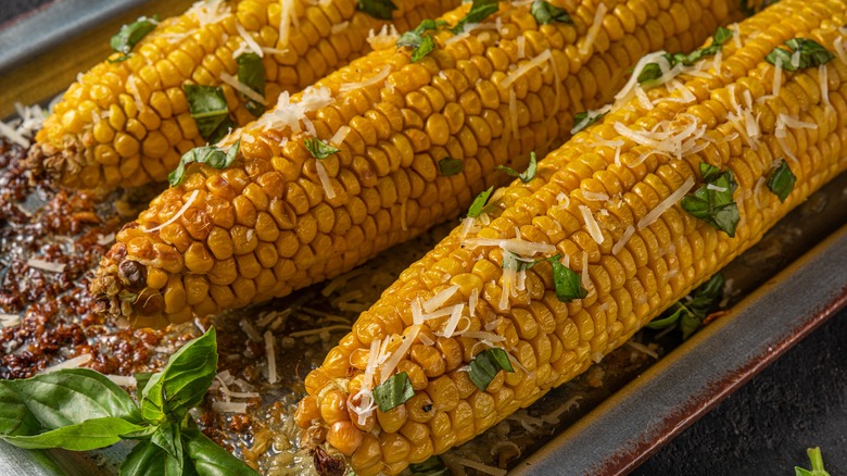 Oven-roasted corn on the cob topped with cheese and herbs