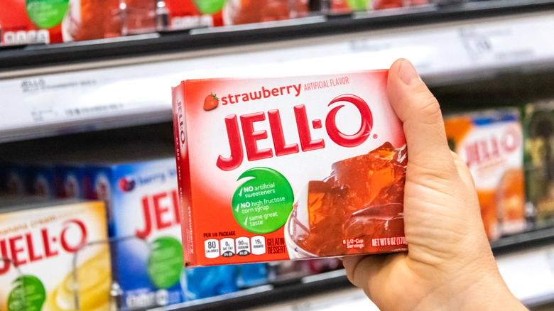 hand holding a box of strawberry jello