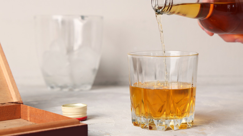 Rum being poured into a glass on a bar