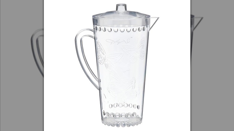 Clear pitcher embossed with butterfly design with a handle and lid