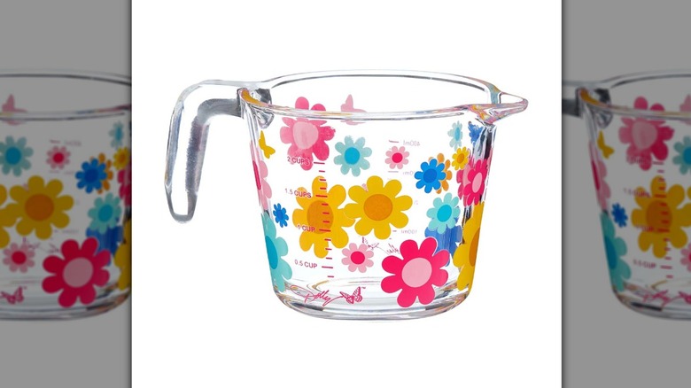 Glass measuring cup with pink, blue, and yellow floral decoration