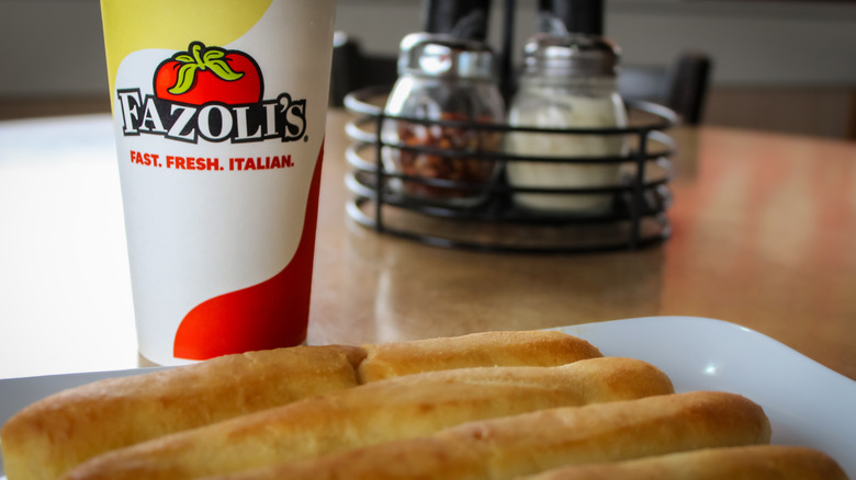 A plate of breadsticks with a drink from Fazoli's restaurant