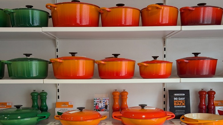 Le Creuset Dutch ovens in orange and blue displayed at a home improvement store