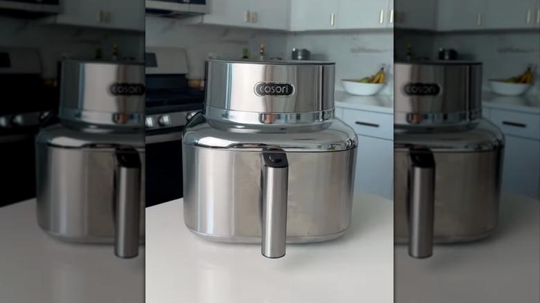 Cosori Iconic stainless steel air fryer on counter.