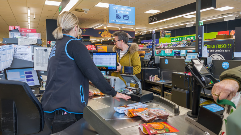 Aldi customers waiting at the checkout of supermarket.