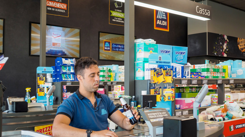 Aldi cashier sitting down while scanning a customer's items