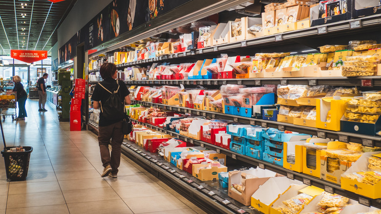 Interior of an Aldi store captured at the chilled section, showing a person stopping by to look at the products.