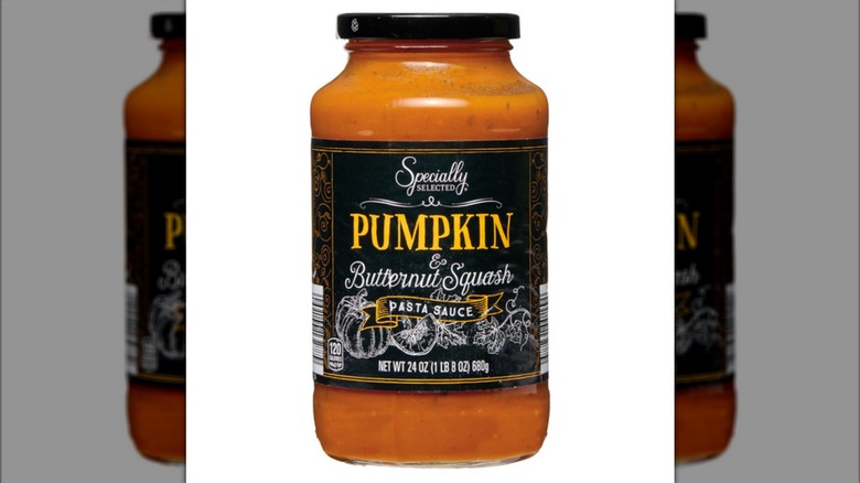 A clear jar showing an orange pasta sauce.