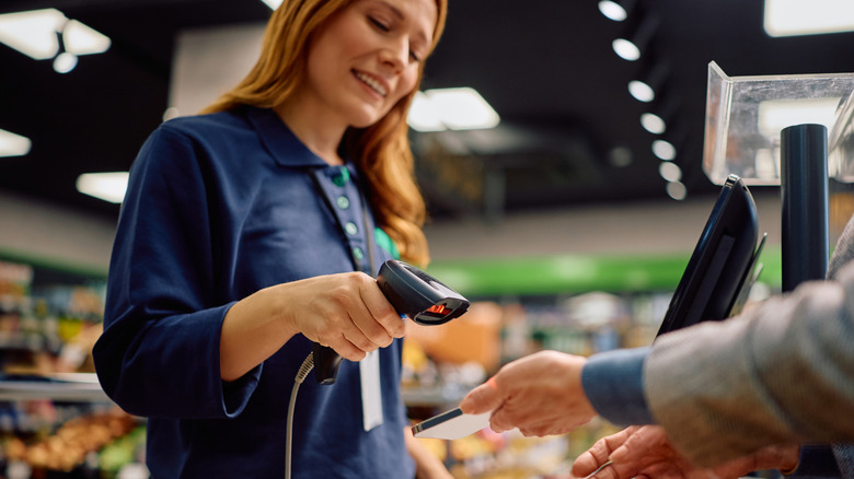 Woman scanning coupon at checkout