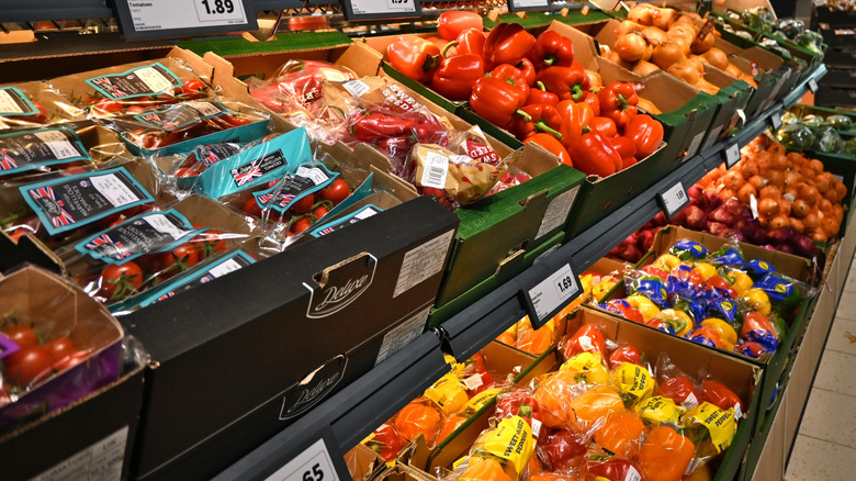 Produce section of store with vegetables wrapped in plastic packaging.