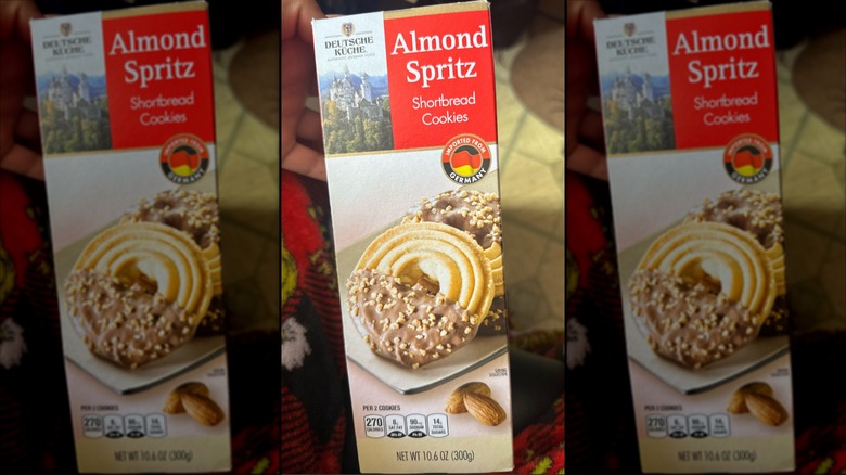 A hand holding a box of Deutsche Küche Almond Spritz Shortbread Cookies