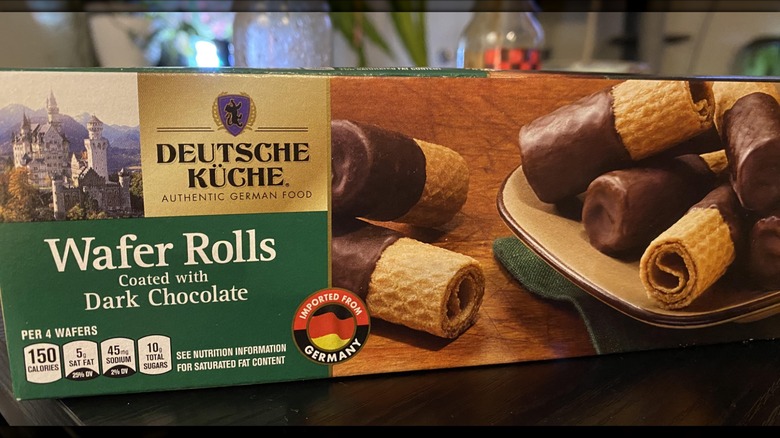 A box of Deutsche Küche Dark Chocolate Coated Wafer Rolls on a wooden table
