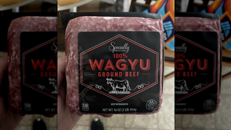hand holding a package of Specially Selected Wagyu Ground Beef