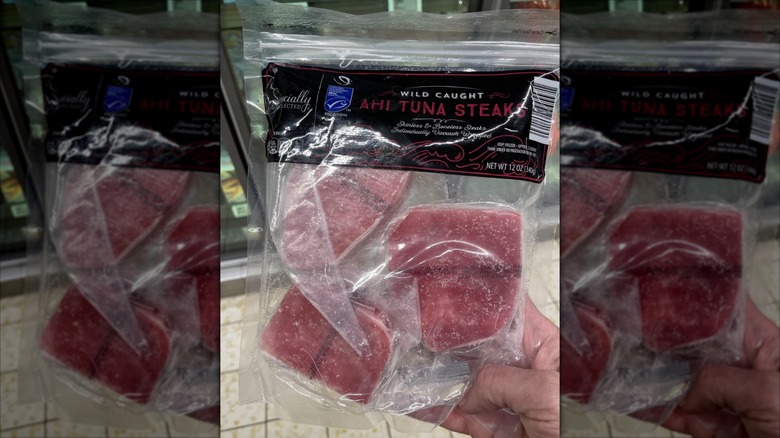 hand holding a package of Specially Selected Wild Caught Ahi Tuna Steaks