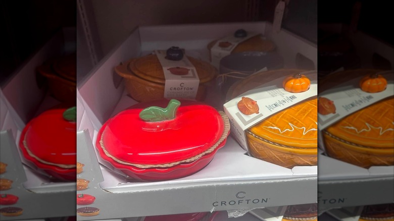 Hand holding Aldi's Crofton Ceramic Pie or Brie Baker with an orange pumpkin knob in store