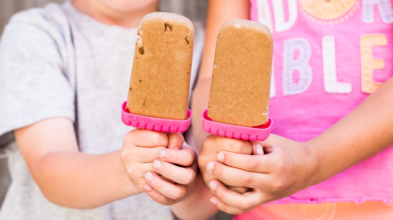 two children holding homemade pudding pops