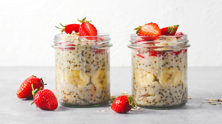 Overnight Oats with Fresh Strawberry, Banana and Chia Seeds in Jars on Grey Background, Healthy Snack or Breakfast