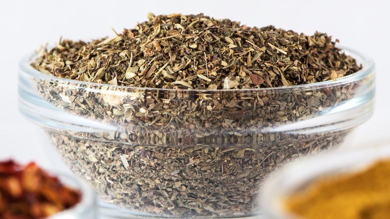 A large glass bowl full of Italian seasoning
