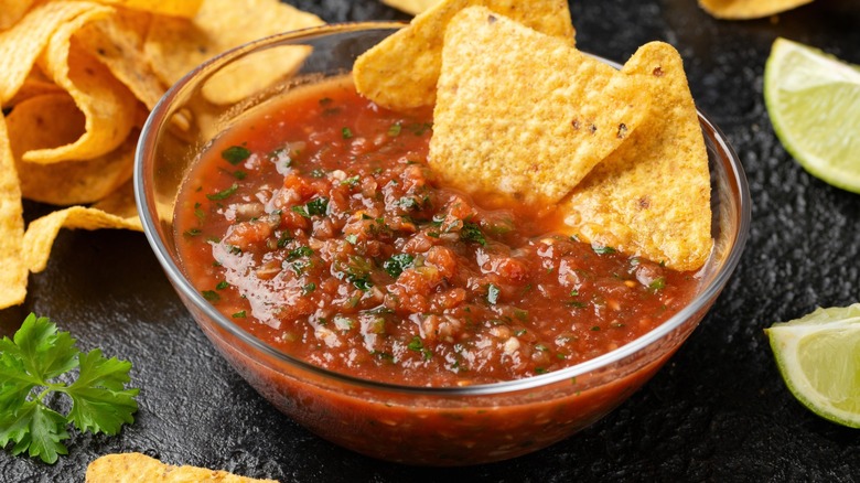 Bowl of red salsa on black background.