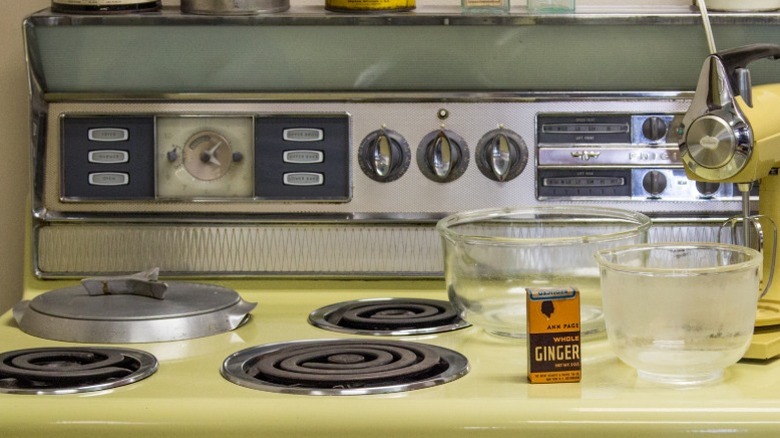 A retro-style stovetop featuring a deep well cooker on display at a museum.