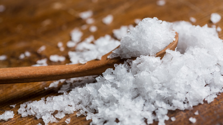 Maldon salt in a pile with a wooden spoon