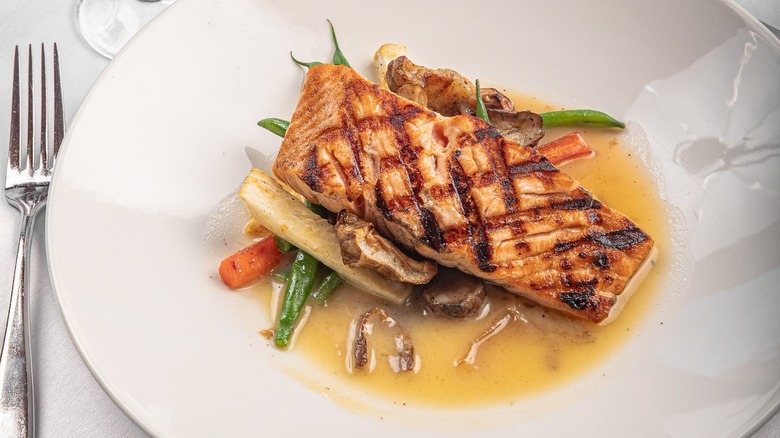 A plate of grilled salmon with vegetables at Canoe in Atlanta