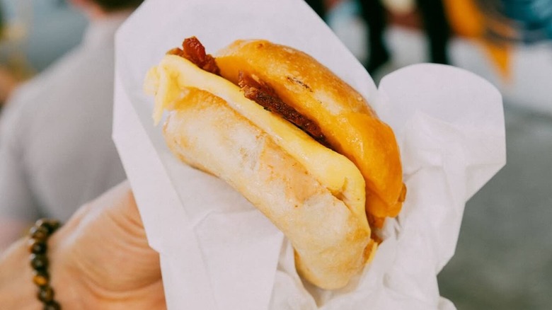 A person holding a breakfast sandwich at Supernatural in Tampa, Florida