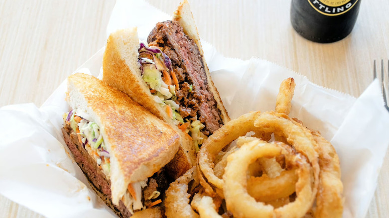 The Slaw Burger with onion rings at The Red Eyed Mule in Marietta, Georgia