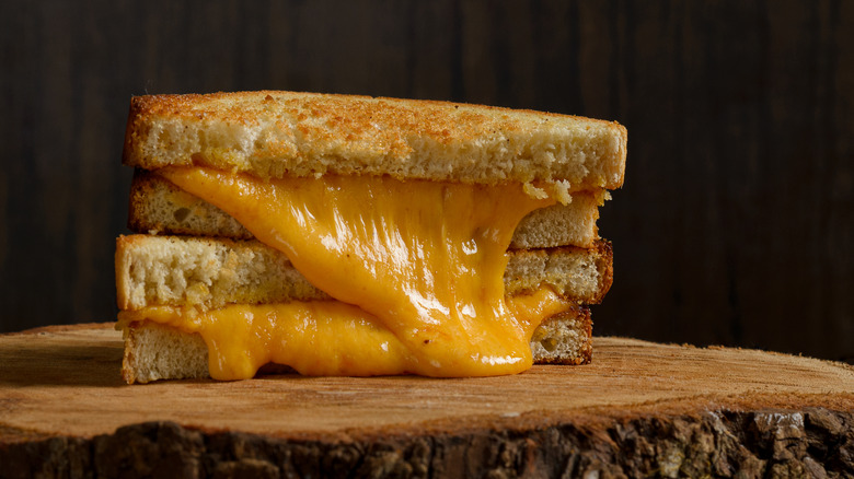 A grilled cheese sandwich on a wooden board.