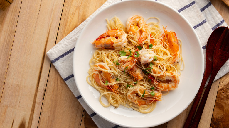 Angel hair pasta with shrimp on a white plate
