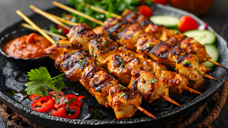 Chicken skewers on a dark plate