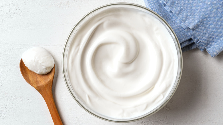 Bowl of creamy cream cheese with a wooden spoon.