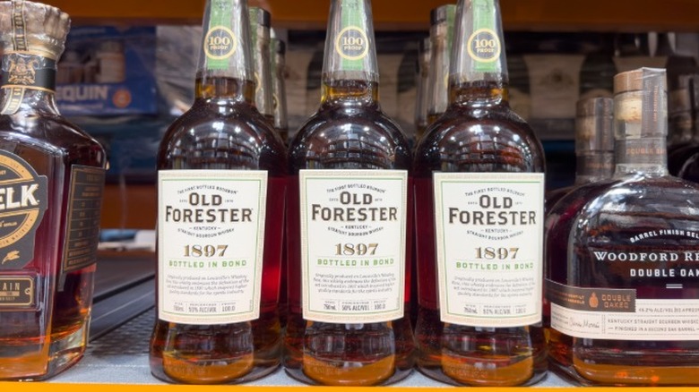 Bottles of Old Forester on a store shelf in between other types of bourbon.
