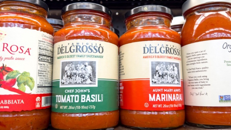 Jars of DelGrosso pasta sauce on a store shelf in between other jars of pasta sauce.