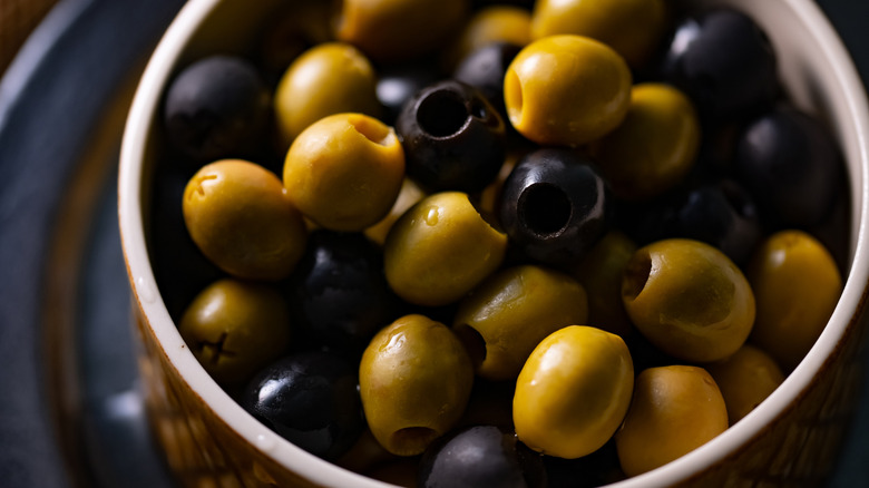 Close-up of a bowl of green and black olives