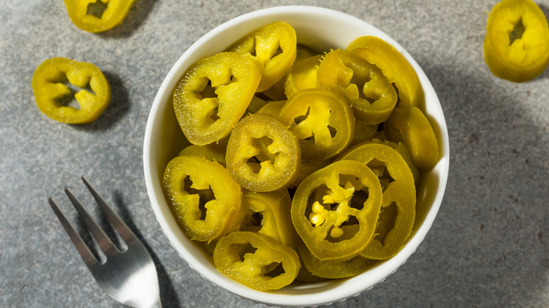 Overhead view of a bowl full of sliced jalapeños