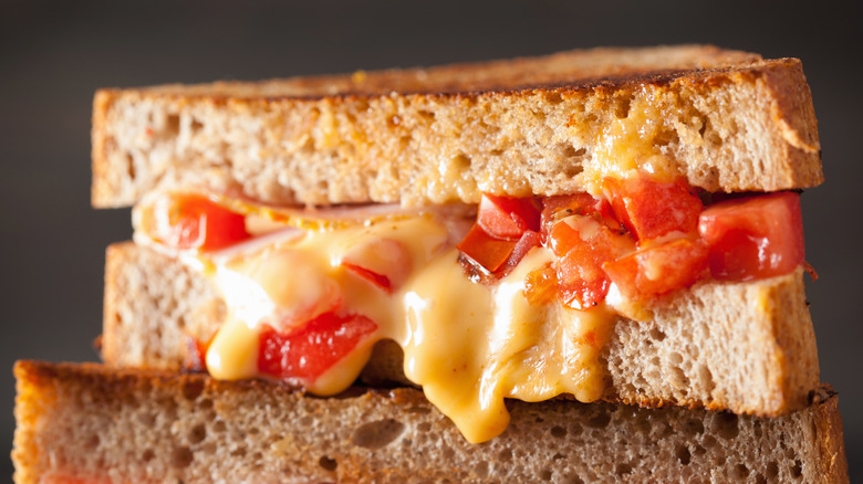 Grilled cheese sandwich with diced tomatoes and ham